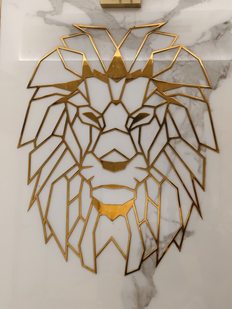 Gold geometric lion crest on marble